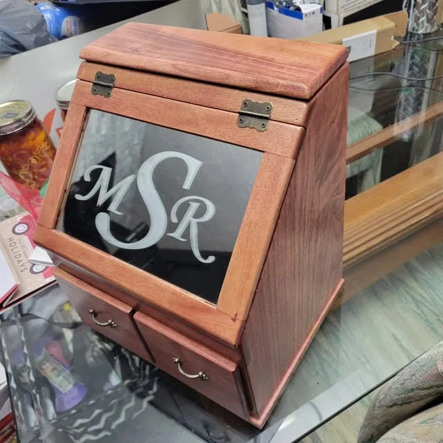 Wooden jewelry box with a glass lid etched with the initials MSR.