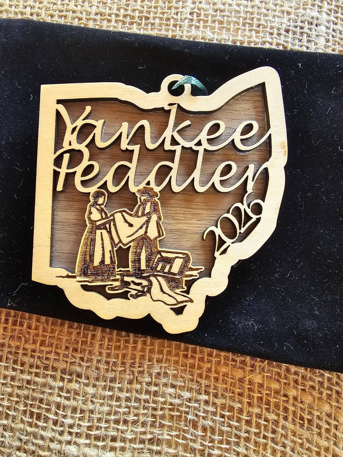 A layered wooden Yankee Peddler ornament in the shape of Ohio.