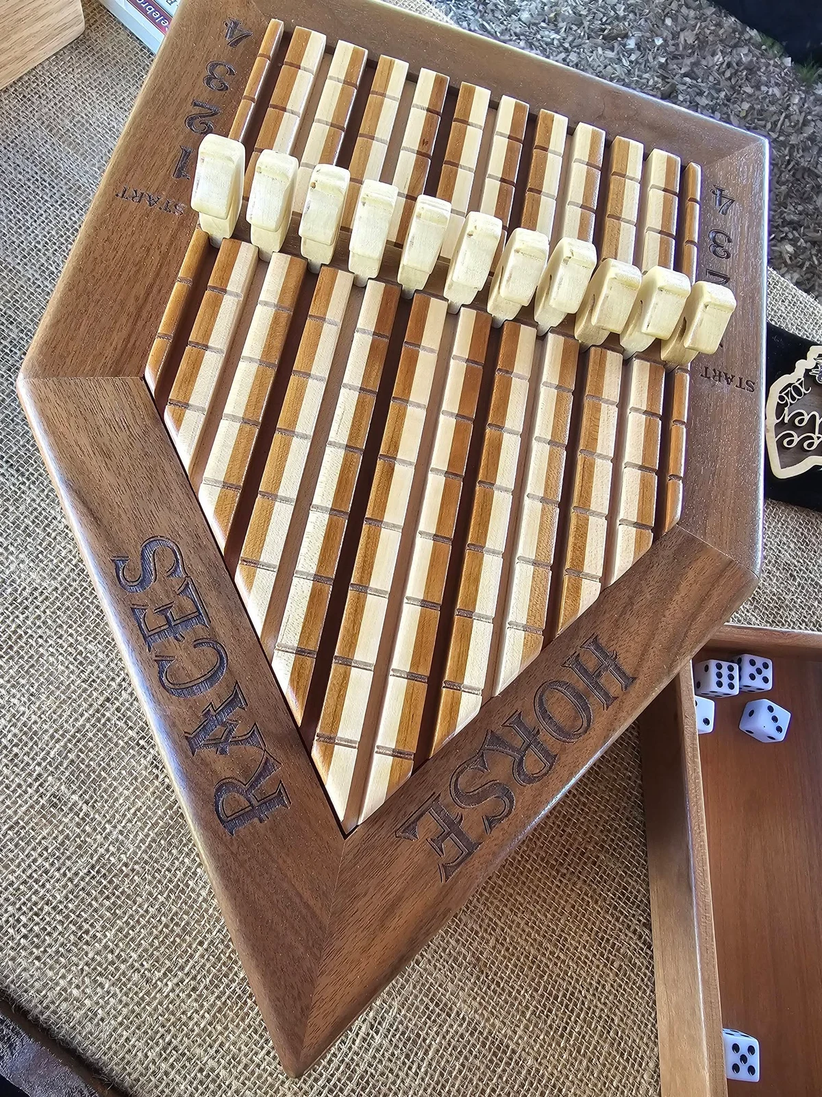 A handmade wooden horse-racing game with numbered lanes and horse pieces.